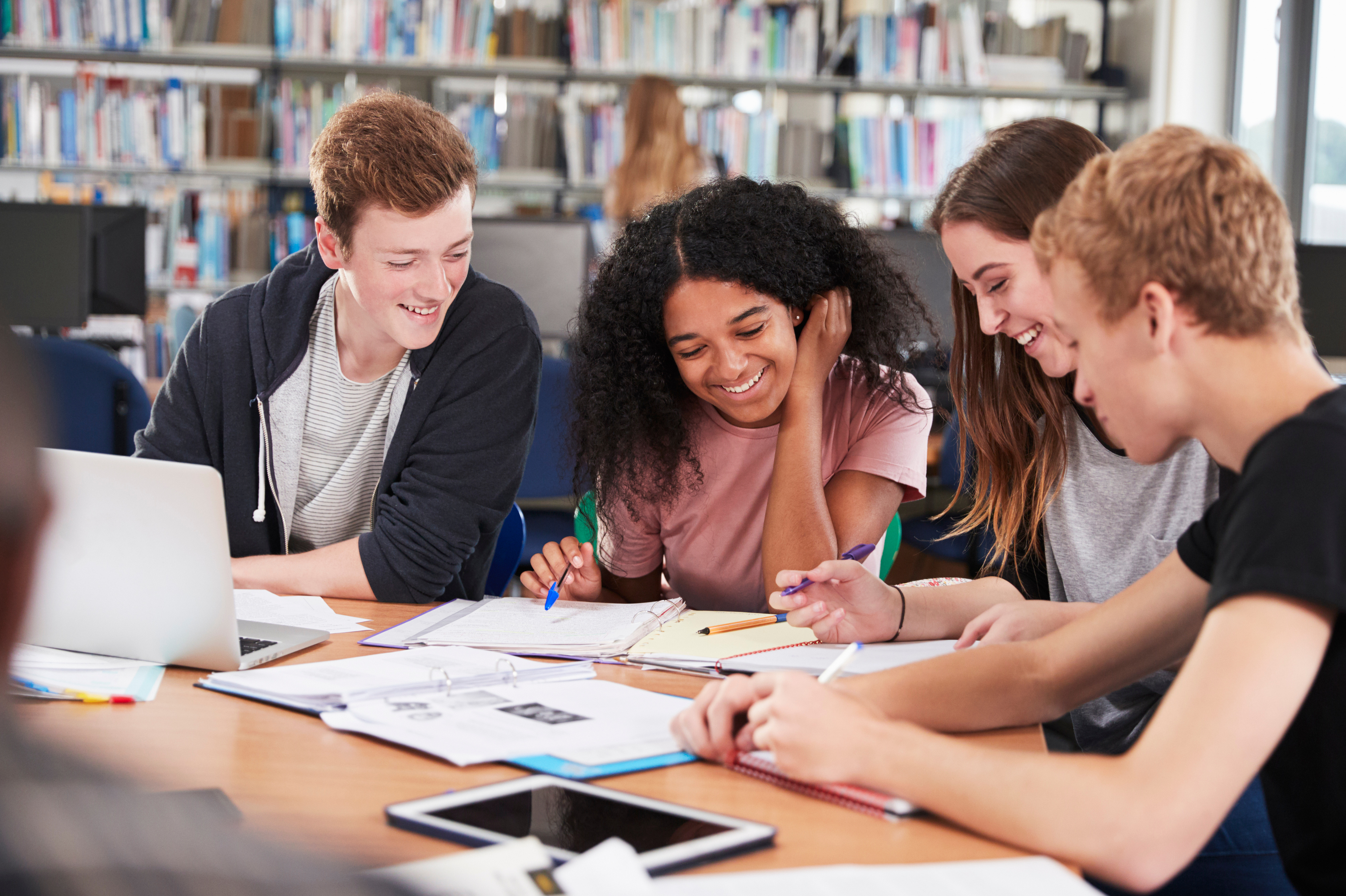 Group of College Students Collaborating on Project in Library